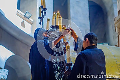 Coptic priests lighting oil candles, Good Friday, Holy Sepulchre church Editorial Stock Photo