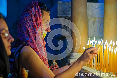Pilgrim lighting a candle, Orthodox Good Friday, Holy Sepulchre church Editorial Stock Photo