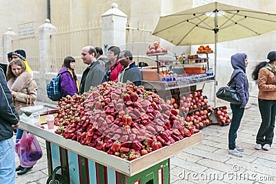 JERUSALEM, ISRAEL - FEBRUARY 16, 2013: Tourists buying strawberry on the streets of city Editorial Stock Photo