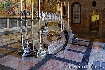 Believer men kneel and pray in the Church of the Holy Sepulchre in Christian quarter in the old city of Jerusalem, Israel Editorial Stock Photo