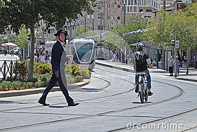 Jerusalem, Israel - 18 May,2018: A religious crosses the road on a tramway track. Violation of traffic rules, accident. Editorial Stock Photo