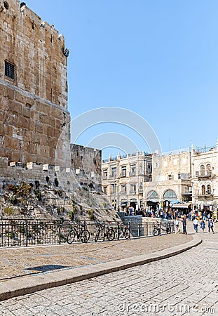 The corner of the fortress wall surrounding Tower of David and crowded Omar Ben el-Hatab street near Jaffa Gate in the old city of Editorial Stock Photo