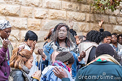 A group of pilgrims believers make a mass prayer near the outer walls of Dormition Abbey in old city of Jerusalem, Israel Editorial Stock Photo
