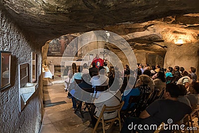 A preacher gives a sermon to visitors in the hall of the Grotto of Gethsemane on foot of the mountain Mount Eleon - Mount of Editorial Stock Photo