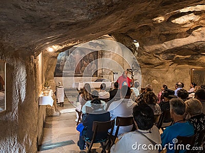 A preacher gives a sermon to visitors in the hall of the Grotto of Gethsemane on foot of the mountain Mount Eleon - Mount of Editorial Stock Photo