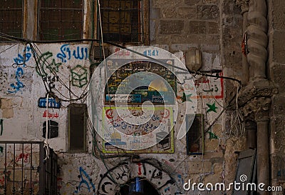 Posters with Koran suras hang on the wall near the gate Gate of the Cotton Merchants on the Temple Mount in the Old City in Editorial Stock Photo