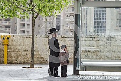 JERUSALEM, ISRAEL, 05.04.2018. Ultra Orthodox Jewish boys waiting for a bus at a stop in the orthodox Jerusalem area Editorial Stock Photo