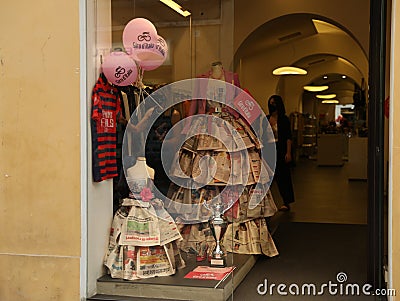 JESI, ITALY - MAY 17, 2022: Beautiful dresses made of newspapers in boutique, view from outside Editorial Stock Photo