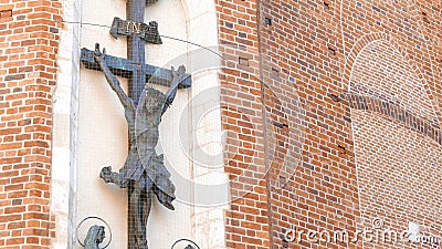 Jesus Christ on the cross figure, sculpture on Mariacki Church in Krakow, detail closeup, nobody, pan down. Christianity, Editorial Stock Photo