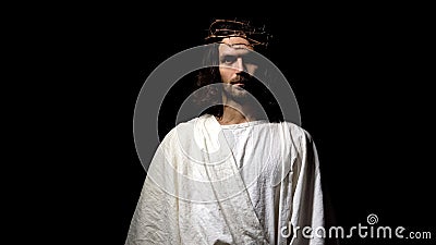 Jesus in robe and crown of thorns looking into camera, Christian faith, religion Stock Photo