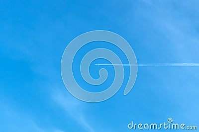 Jet aircraft flying on the high altitude against the backdrop of a clear blue sky. Airplane with two condensation trail on clouds Stock Photo