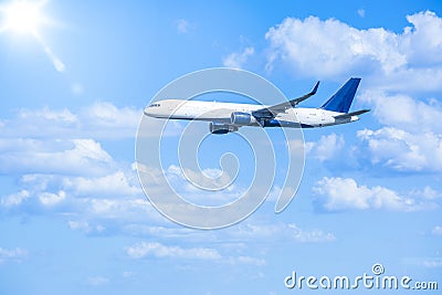 Jet Airplane flying through the blue sky on a sunny day Stock Photo