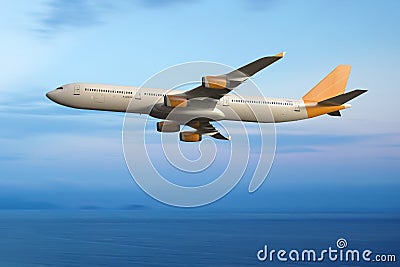 Jet airplane flying in the sky. Ocean and clouds background Stock Photo