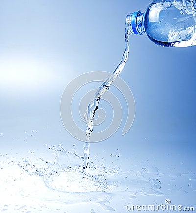 A jet of sparkling water escaping from the bottle. White blue tone image. Stock Photo