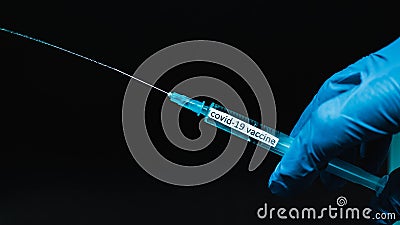 A jet of a syringe from a needle,a medical professional demonstrates a medicine for covid-19,the text coronavirus on a syringe,clo Stock Photo