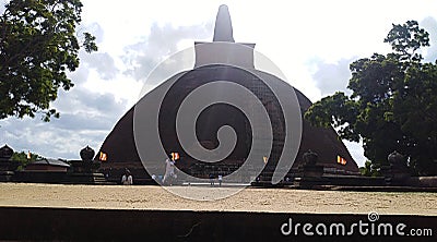 Jethawana Stupa, Huge, brick-based Buddhist stupa topped by an illuminated pinnacle & surrounded by monastery ruins. Stock Photo