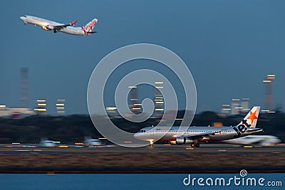 Jetstar Airways Airbus A320 twin engine passenger aircraft lands at Sydney Airport at night Editorial Stock Photo