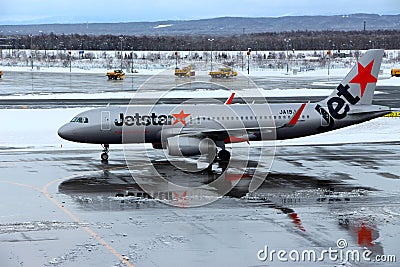 Jetstar plane getting ready to take off at Chitose airport on a snowy day Sapporo Editorial Stock Photo