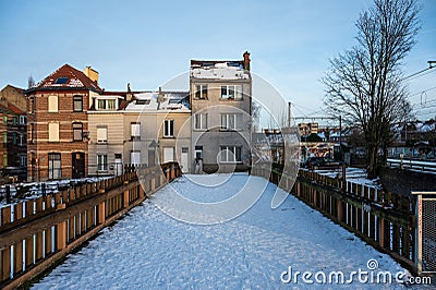 Jette, Brussels, Belgium - Pedestrian bridge covered with snow and residential houses Editorial Stock Photo