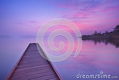 Jetty on a still lake at dawn in The Netherlands Stock Photo