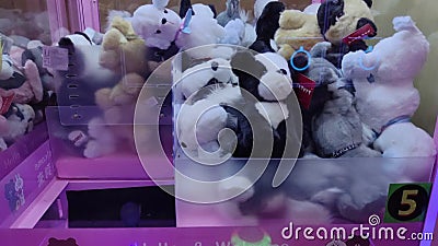 Jeu d'arcade coloré jouet machine à grue à mâchoires où les gens peuvent gagner des jouets et d'autres prix. banque de vidéos Jeu d'arcade coloré jouet machine à grue à mâchoires où les gens peuvent gagner des jouets et d'autres prix. banque de vidéos