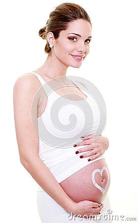 Jeune femme brune enceinte avec un coeur sur le ventre. Stock Photo