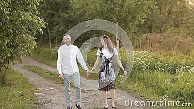 Jeune homme et femme marchant dans un pré vert dans le parc en se tenant la main en été Romance, amour, relation clips vidéos Jeune homme et femme marchant dans un pré vert dans le parc en se tenant la main en été Romance, amour, relation clips vidéos