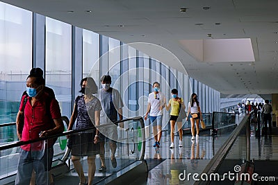 Jewel Changi Airport: visitors wearing face masks walking on travelator; social distancing. In phase 2 reopening Editorial Stock Photo