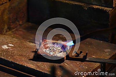 Jeweler is melting gold and silver granules in a crucible with a Stock Photo