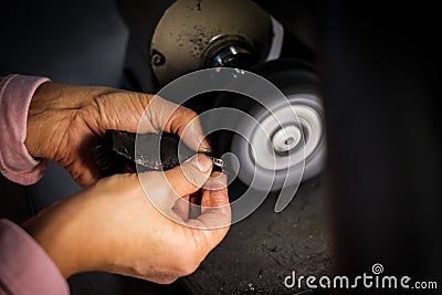 Jeweler polishes gold ring on bench grinder in jewellers workshop Stock Photo