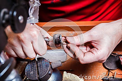 Jeweler polishes golden earring Stock Photo