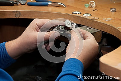 Jeweler polishes jewelry pendant Stock Photo