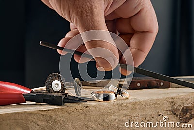 Jeweller craftsman and manually polished two tone rose gold and white gold wedding rings. Stock Photo