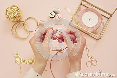 Jewelry designer workplace. Woman hands making handmade jewelry. Freelance fashion femininity workspace in flat lay style. Pastel Stock Photo