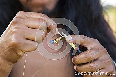 Jewelry maker hands creating earrings from metal string Stock Photo