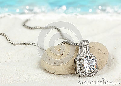 Jewelry pendant with big diamond on sand beach as background Stock Photo