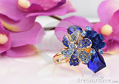 Jewelry ring with blue gems and flower background Stock Photo