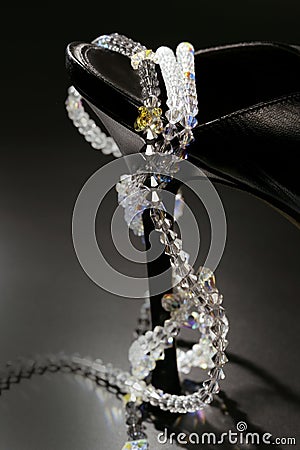 Jewels around a fashion black shoe heel Stock Photo
