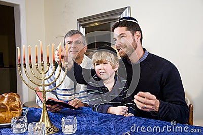 Jewish family lighting Chanukah menorah Stock Photo