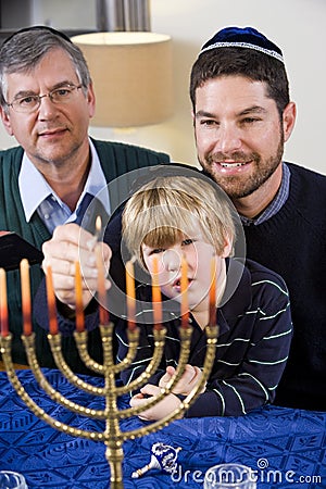 Jewish family lighting Chanukah menorah Stock Photo