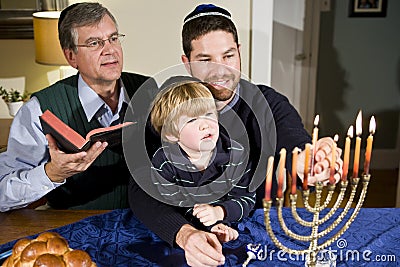 Jewish family lighting Hanukkah menorah Stock Photo