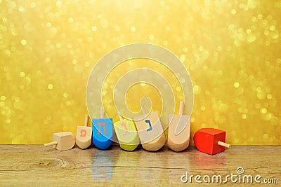 Jewish holiday Hanukkah background with spinning top dreidel over gold bokeh. Copy space for text Stock Photo