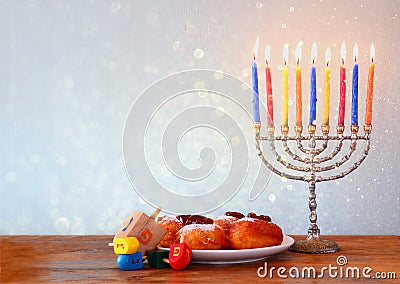 Jewish holiday Hanukkah with menorah, doughnuts over wooden table. retro filtered image Stock Photo