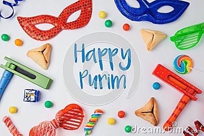 Jewish holiday Purim concept with hamantaschen cookies, carnival mask and noisemaker on white background. Stock Photo
