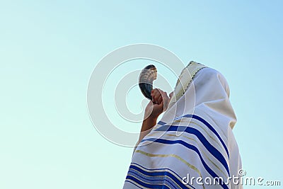 Jewish man blowing the Shofar (horn) of Rosh Hashanah (New Year) Stock Photo