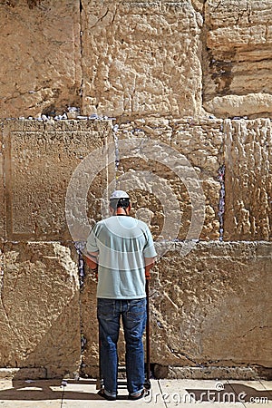 A Jewish man dressed in casual modern clothing prays at the Western Wall Editorial Stock Photo