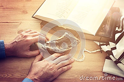 Jewish man hands next to Prayer book, praying, next to tallit. Jewish traditional symbols. Rosh hashanah jewish New Year holiday Stock Photo