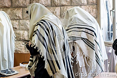 Jewish men praying in a synagogue with Tallit Stock Photo