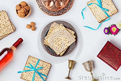 Jewish Passover holiday Pesah celebration concept with matzoh, wine and seder plate over white background. View from above. Flat l Stock Photo