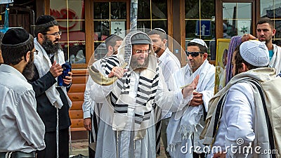 Jewish rabbi hasid surrounded by a crowd of pilgrims blows Shofar. Rosh Hashanah, Jewish New Year. Editorial Stock Photo